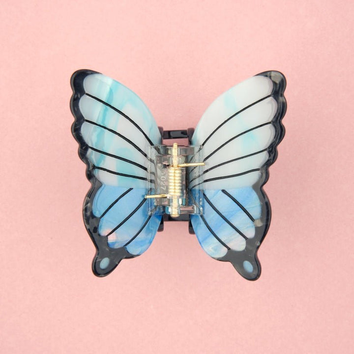 Coucou Suzette Blue Butterfly Hair Claw - Produktbild rosa Hintergrund