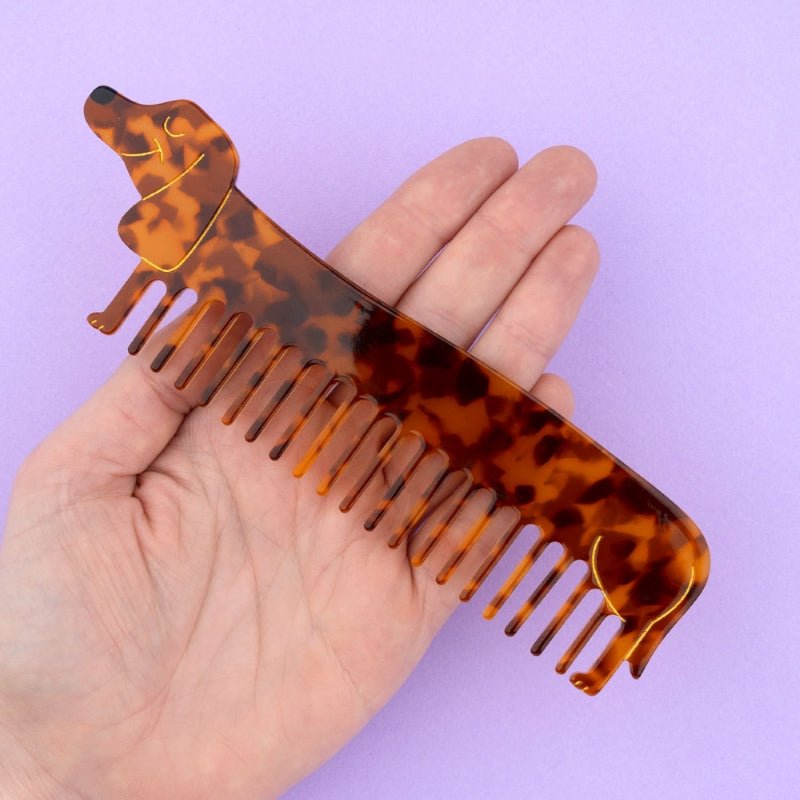 Coucou Suzette Dachshund Comb - Produkt lila Hintergrund mit Handmodel