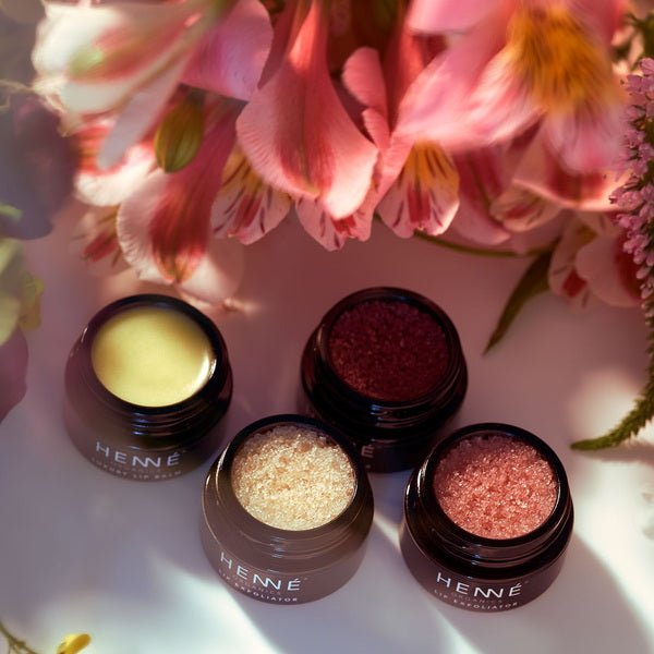 Henné Organics Lip Exfoliator in front of flowers