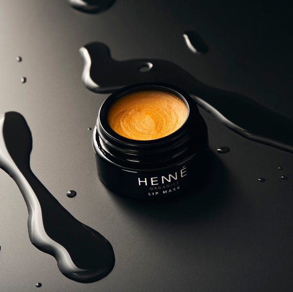 Henné Organics Lip Mask stylish photo of open jar on black surface