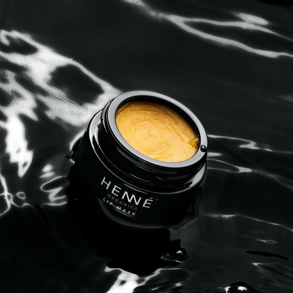 Henné Organics Lip Mask open jar on black watery surface